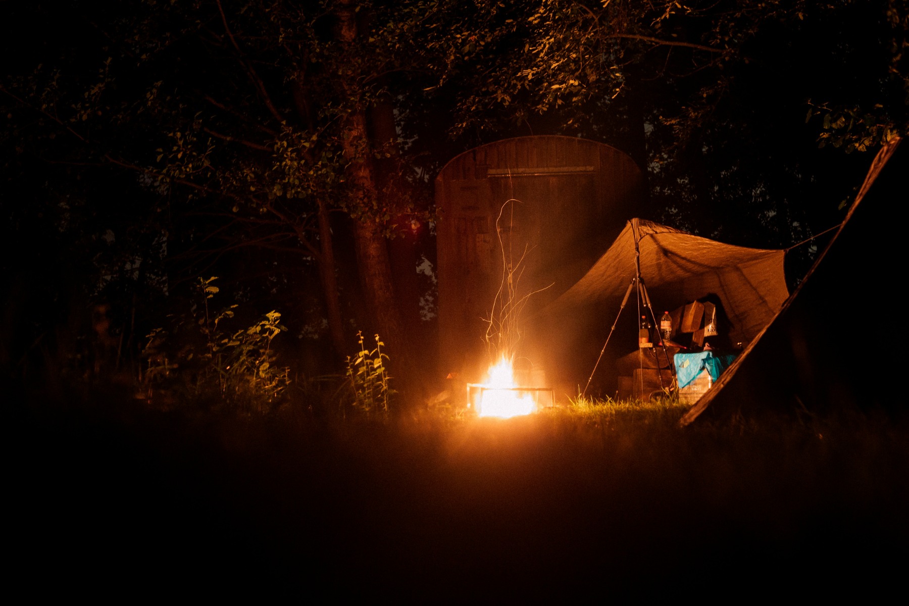 Bonfire near a tent in the forest