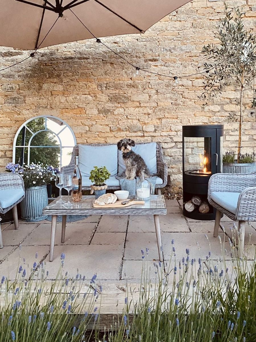 Black bioethanol fireplace in the garden next to a chair and small dog