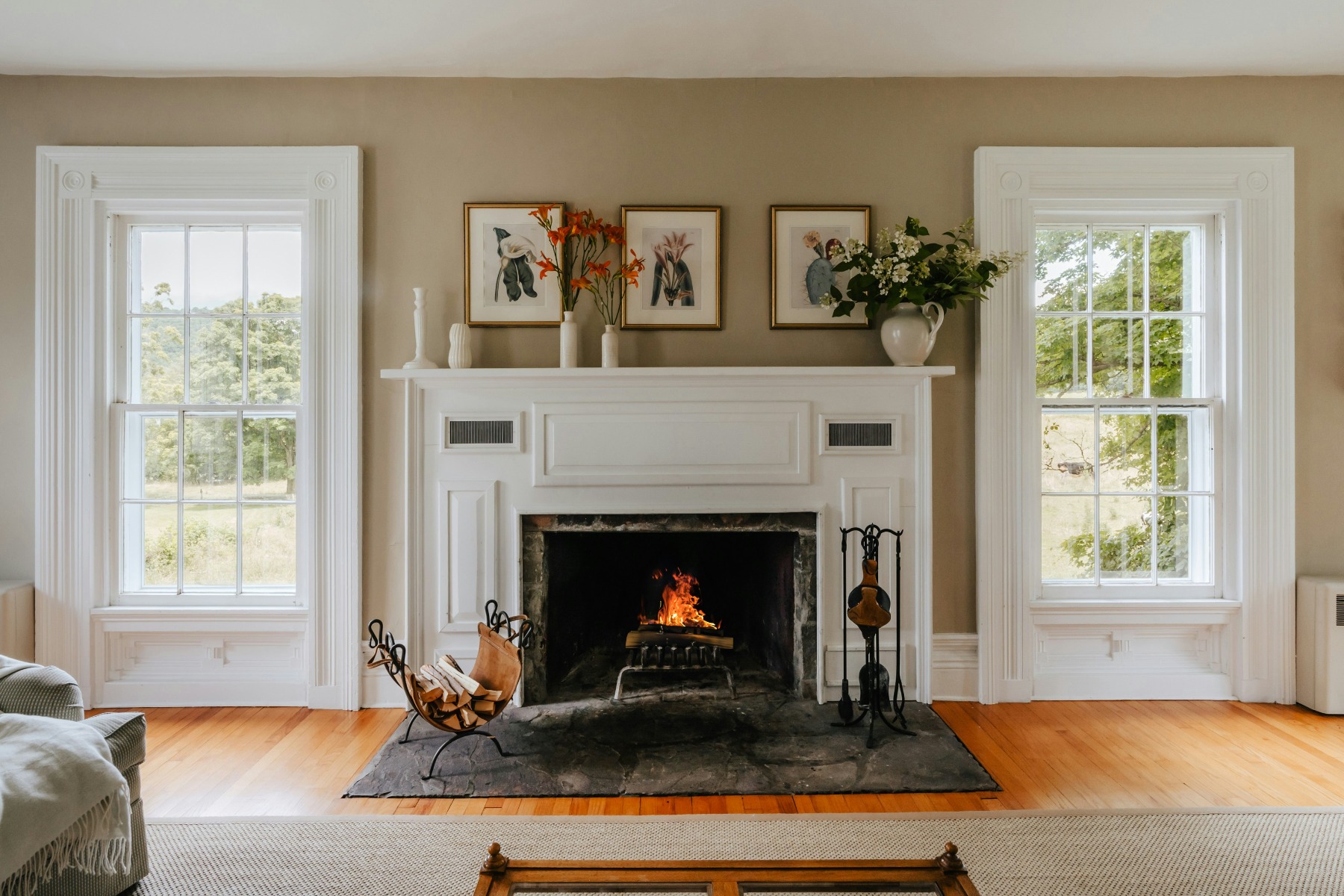 Fireplace with white surround underneath colourful flowers