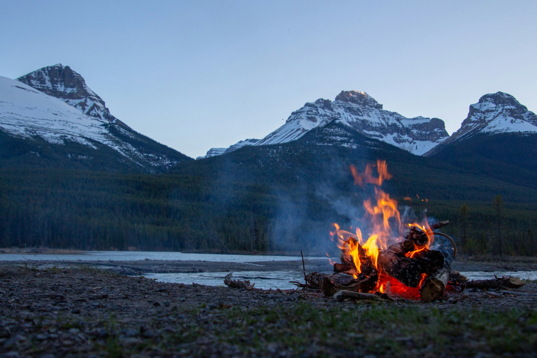 Bonfire in an area surrounded by snowy mountains