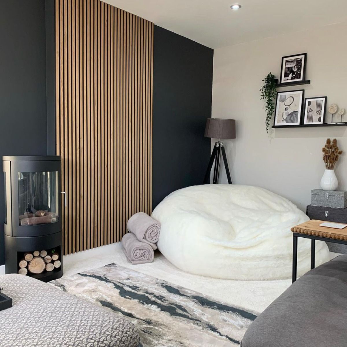 Black bioethanol fireplace in the corner of a room with large white bean bag chair