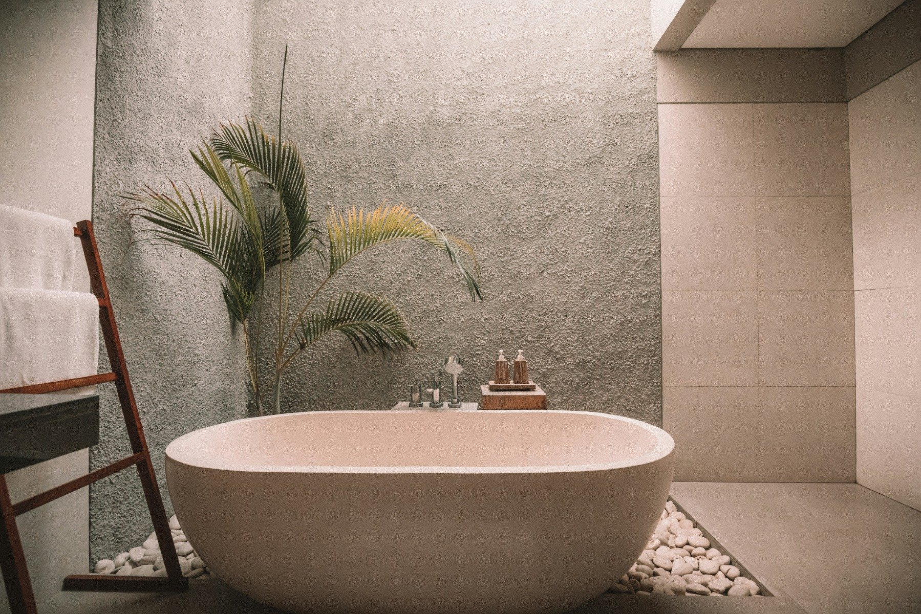 Big white bathtub illuminated by dim lights 