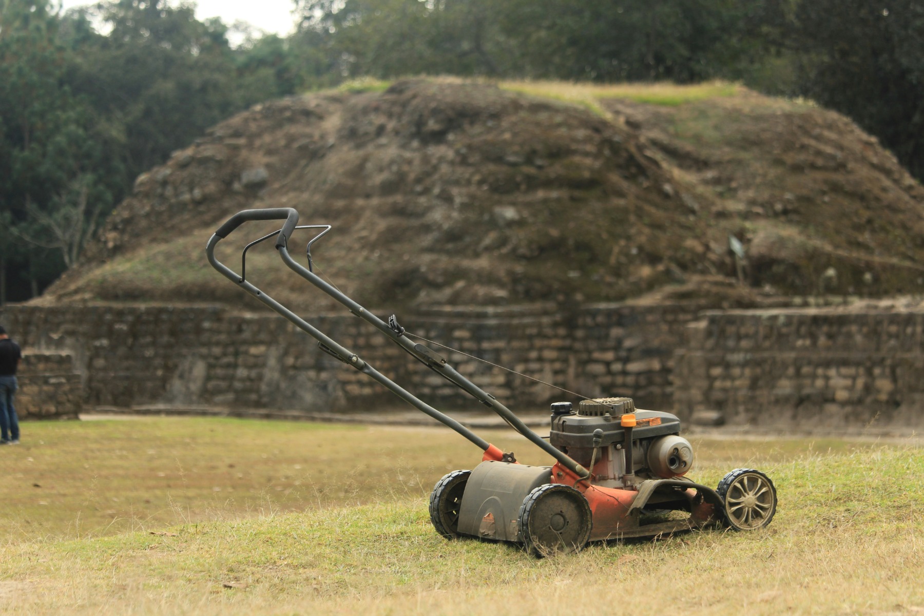 Lawn mower sitting on a dry grass field