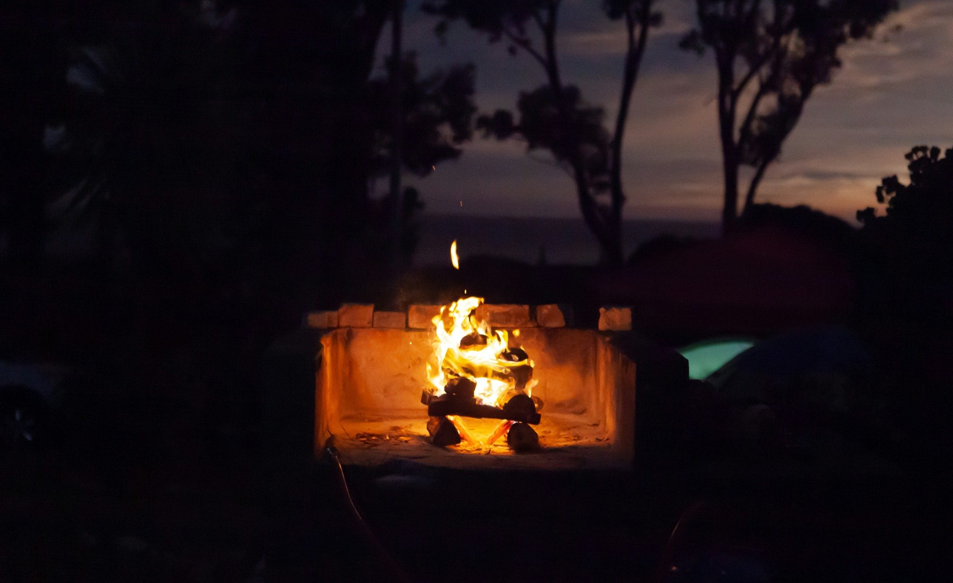 A traditional braai fireplace burning outside at night