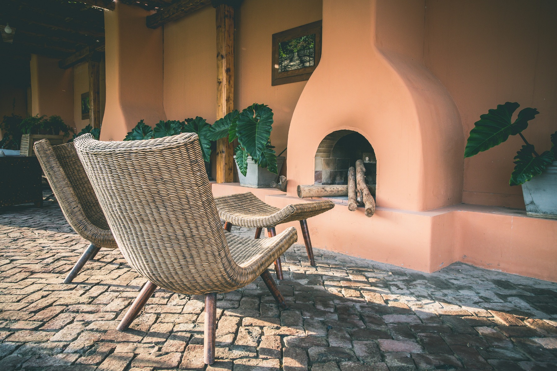 Outside fireplace across some wicker furniture