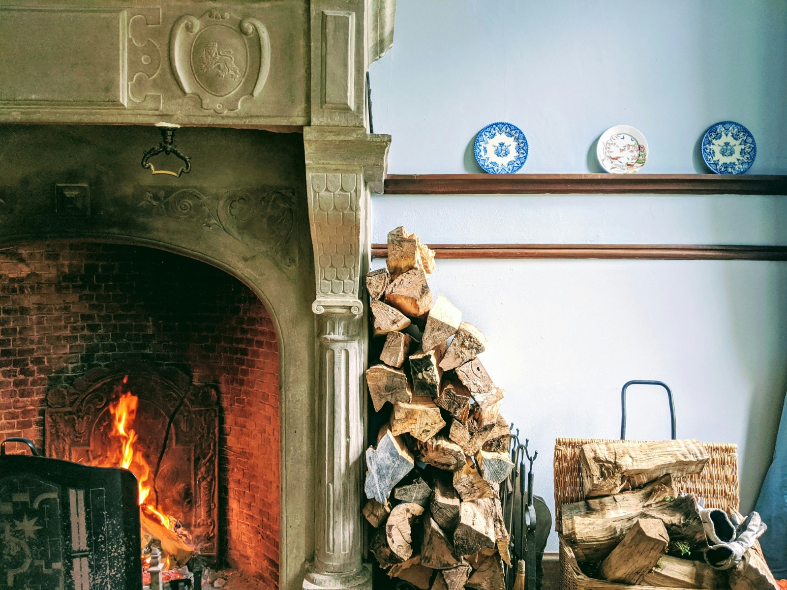 Victorian fireplace next to a pile of woods