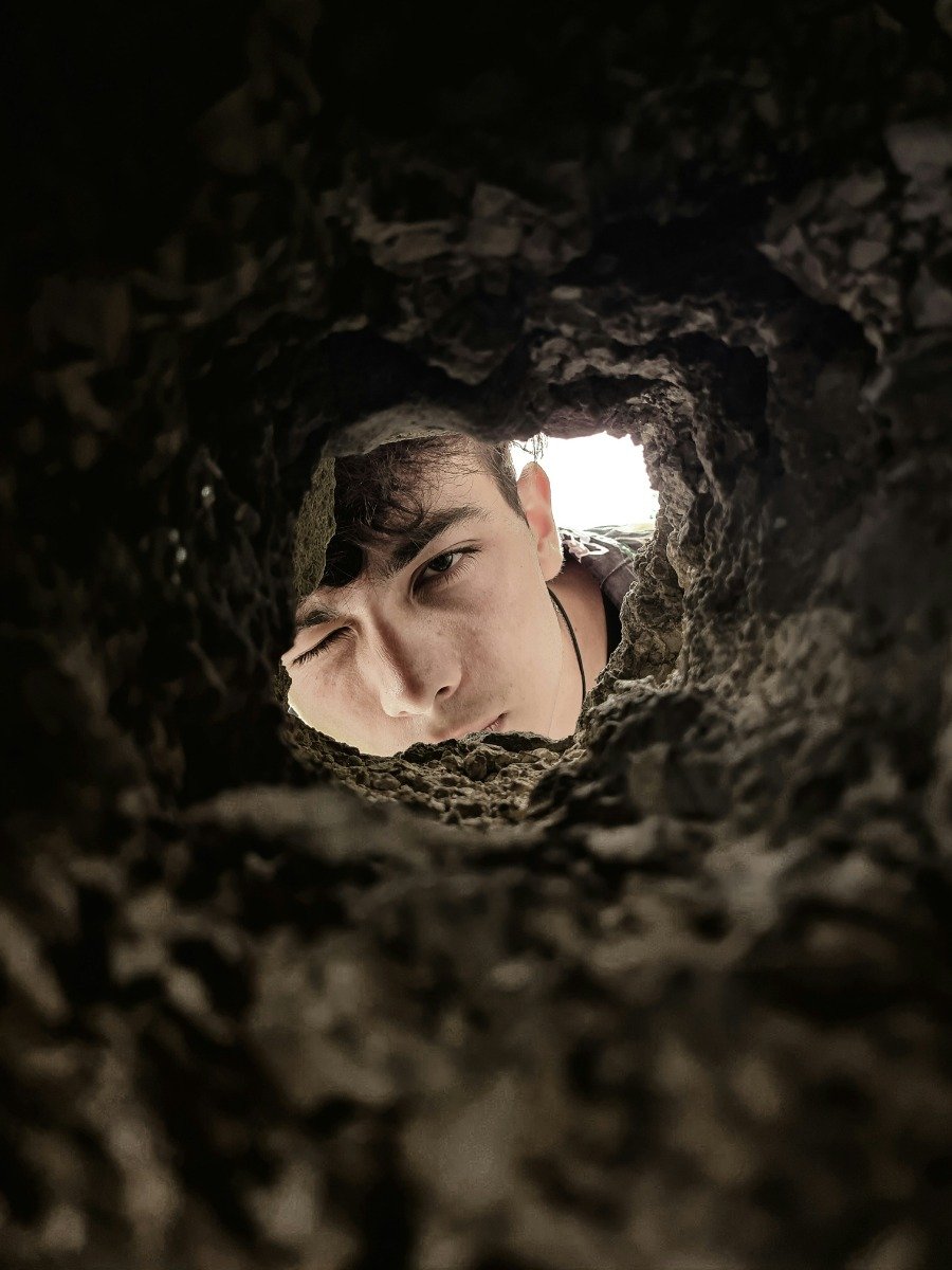 A boy looking through a hole in the wall of his rental property