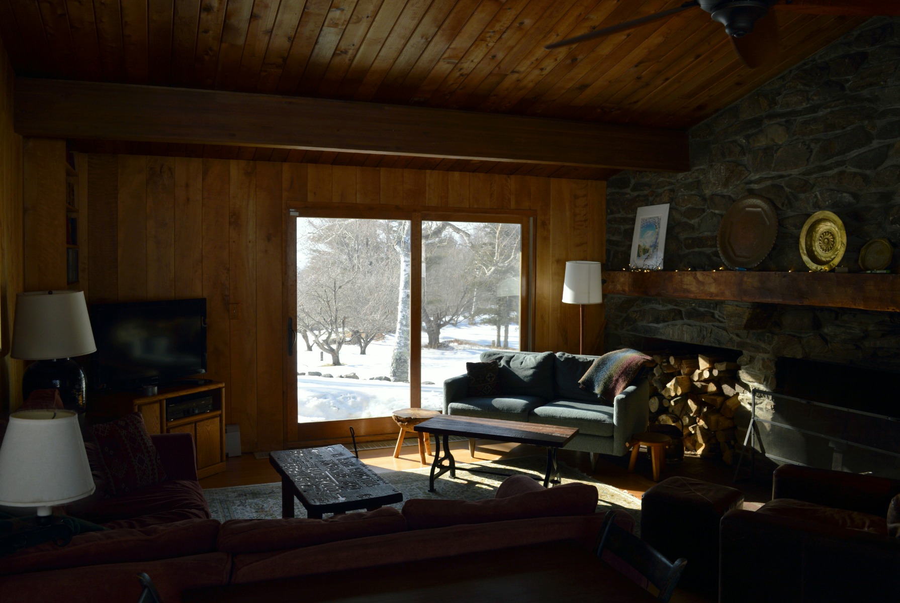 Dark living room with TV and fireplace placed on opposite sides