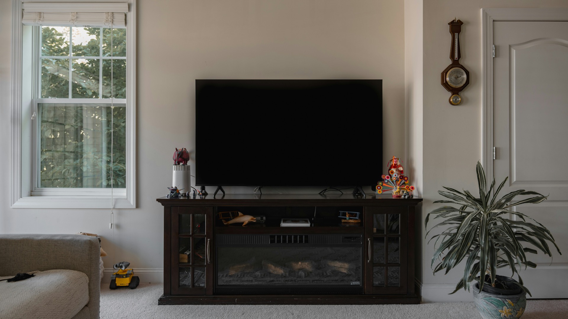 Flat screen TV sitting on a wooden entertainment centre over a fireplace