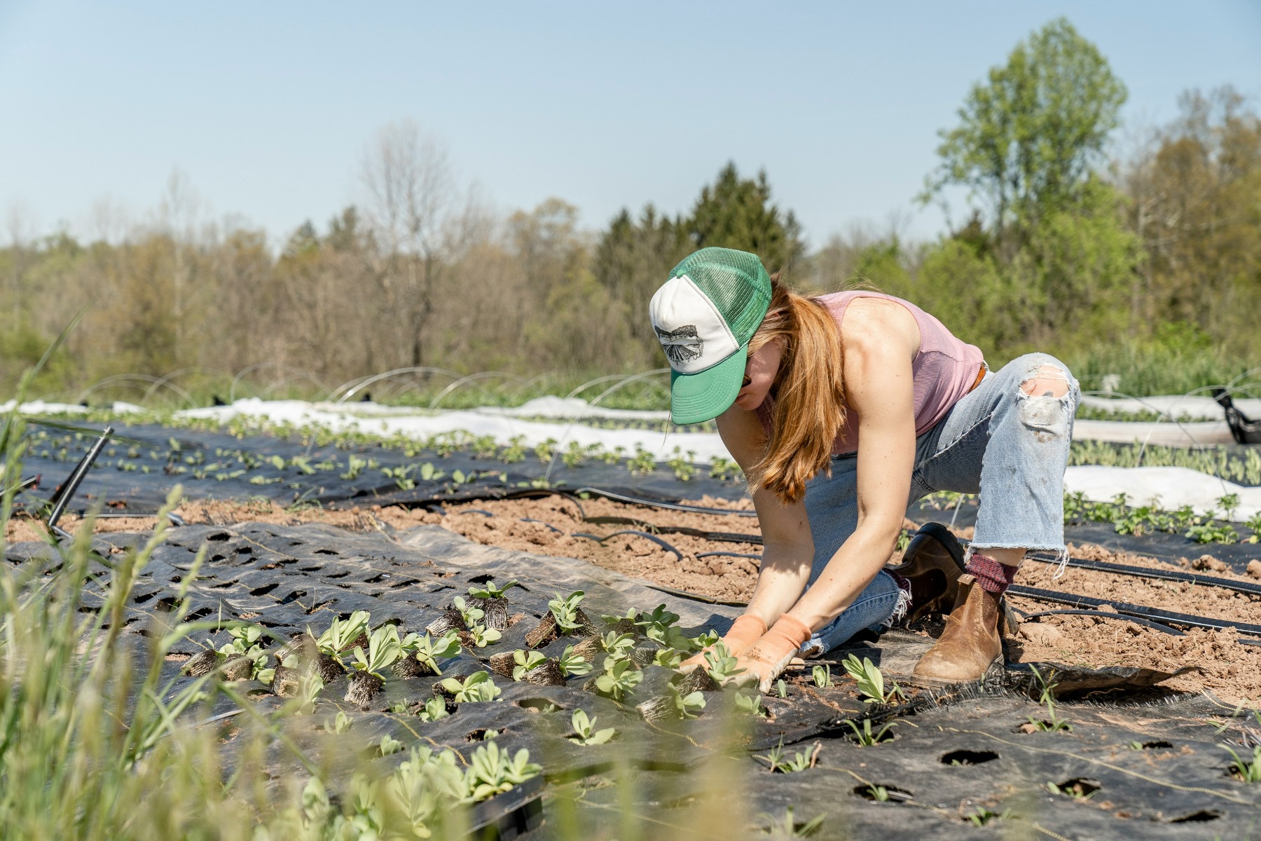 Woman wearing a green hat working in a sustainable garden